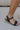 Side view of female model wearing the Londyn Gold Heart Chain Anklet which features gold chain link with a heart medallion
