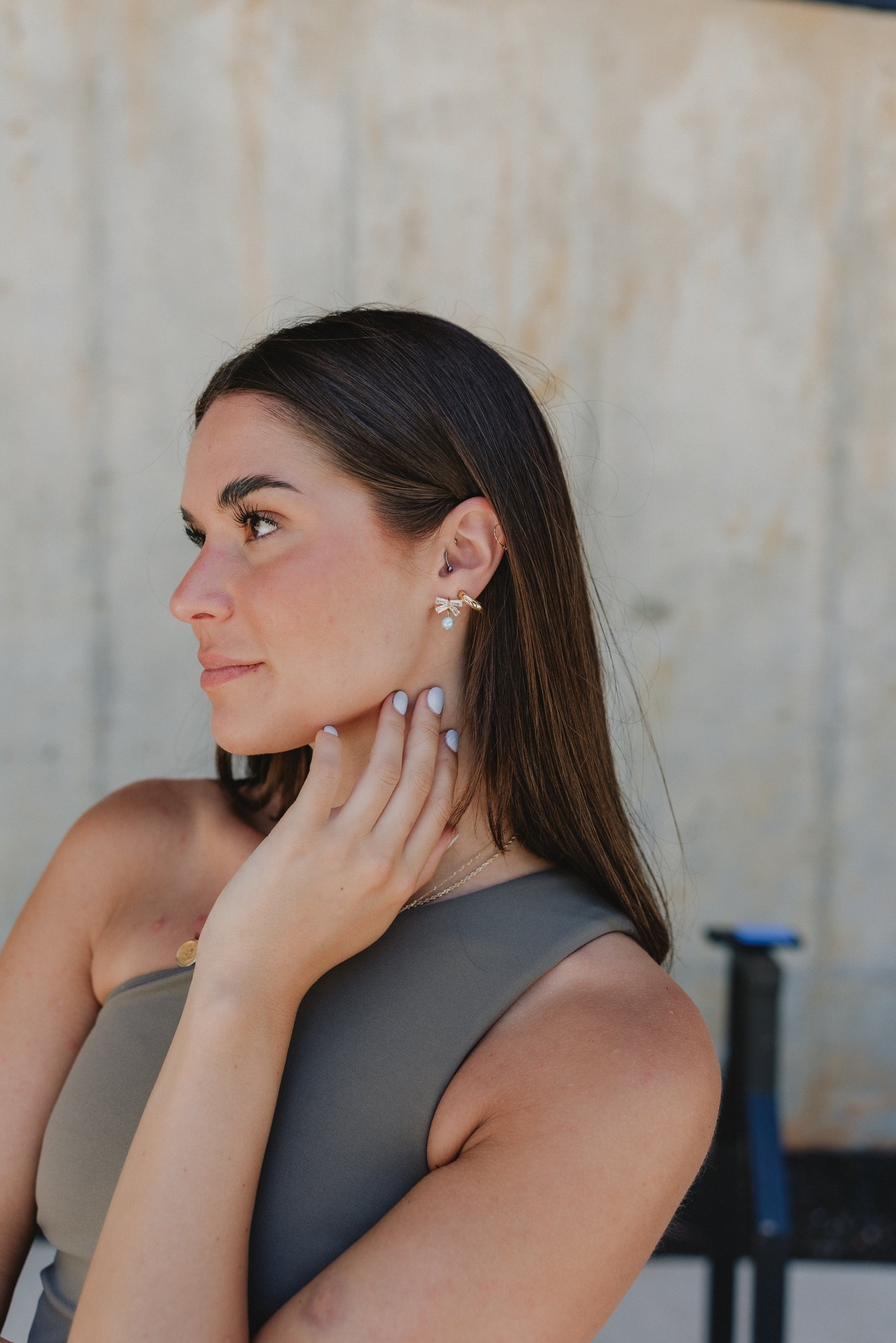 side view of the Talia Turquoise & Rhinestone Bow Stud Earring which features mini rhinestone bow studs with turquoise beads