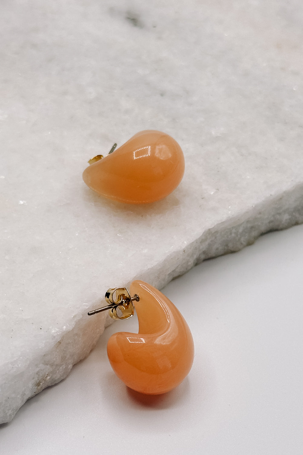 Close up view of the Sophie Peach Scoop Hoop Earring which features peach scooped mini hoops