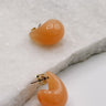 Close up view of the Sophie Peach Scoop Hoop Earring which features peach scooped mini hoops