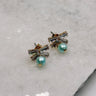 Close up view of the Talia Turquoise & Rhinestone Bow Stud Earring which features mini rhinestone bow studs with turquoise beads