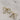 close up view of the Cora Gold & Pearl Bow Stud Earring which features gold bow shaped studs with light pink pearl beads
