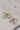 close up view of the Cora Gold & Pearl Bow Stud Earring which features gold bow shaped studs with light pink pearl beads
