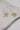 close up view of the Cora Gold & Pearl Bow Stud Earring which features gold bow shaped studs with light pink pearl beads
