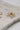 close up view of the Cora Gold & Pearl Bow Stud Earring which features gold bow shaped studs with light pink pearl beads