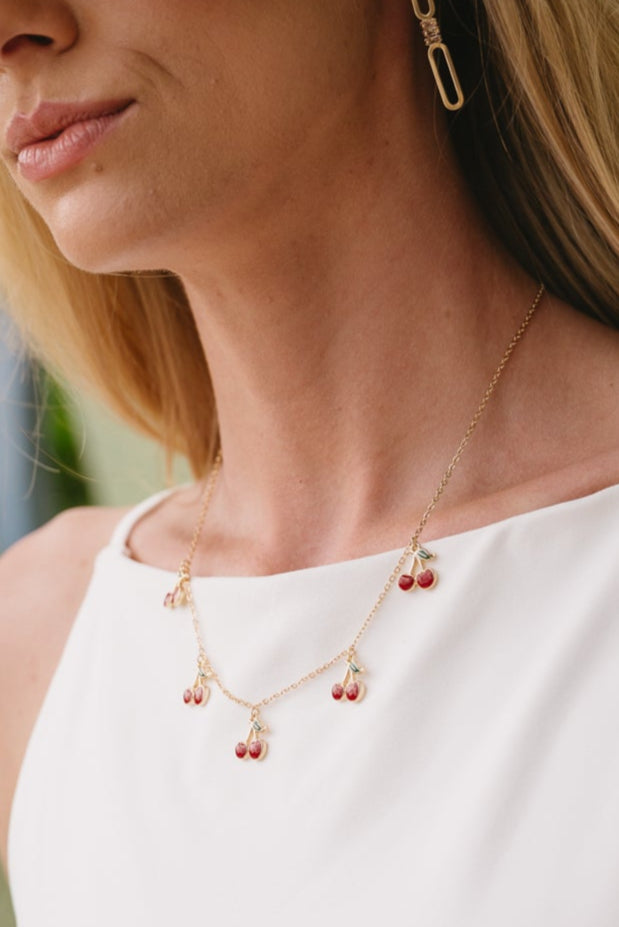 Paulina Gold & Red Cherry Necklace - close up view of necklace on model