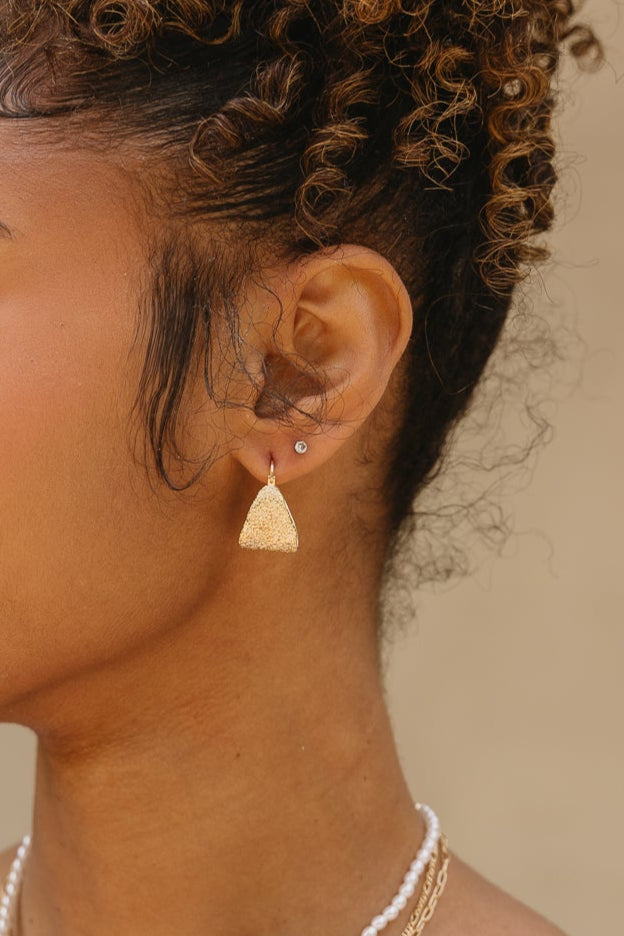 Sami Hammered Gold Hoop Earrings - close up of earrings on model