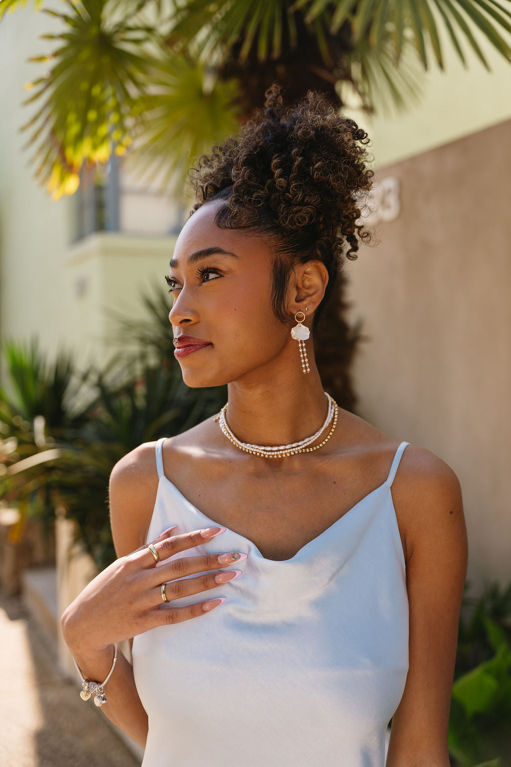 Jesslyn White Petal & Pearl Earrings - side of model wearing earrings