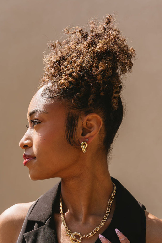 Bianca Gold Twisted Knot Earrings - side view of model wearing earrings