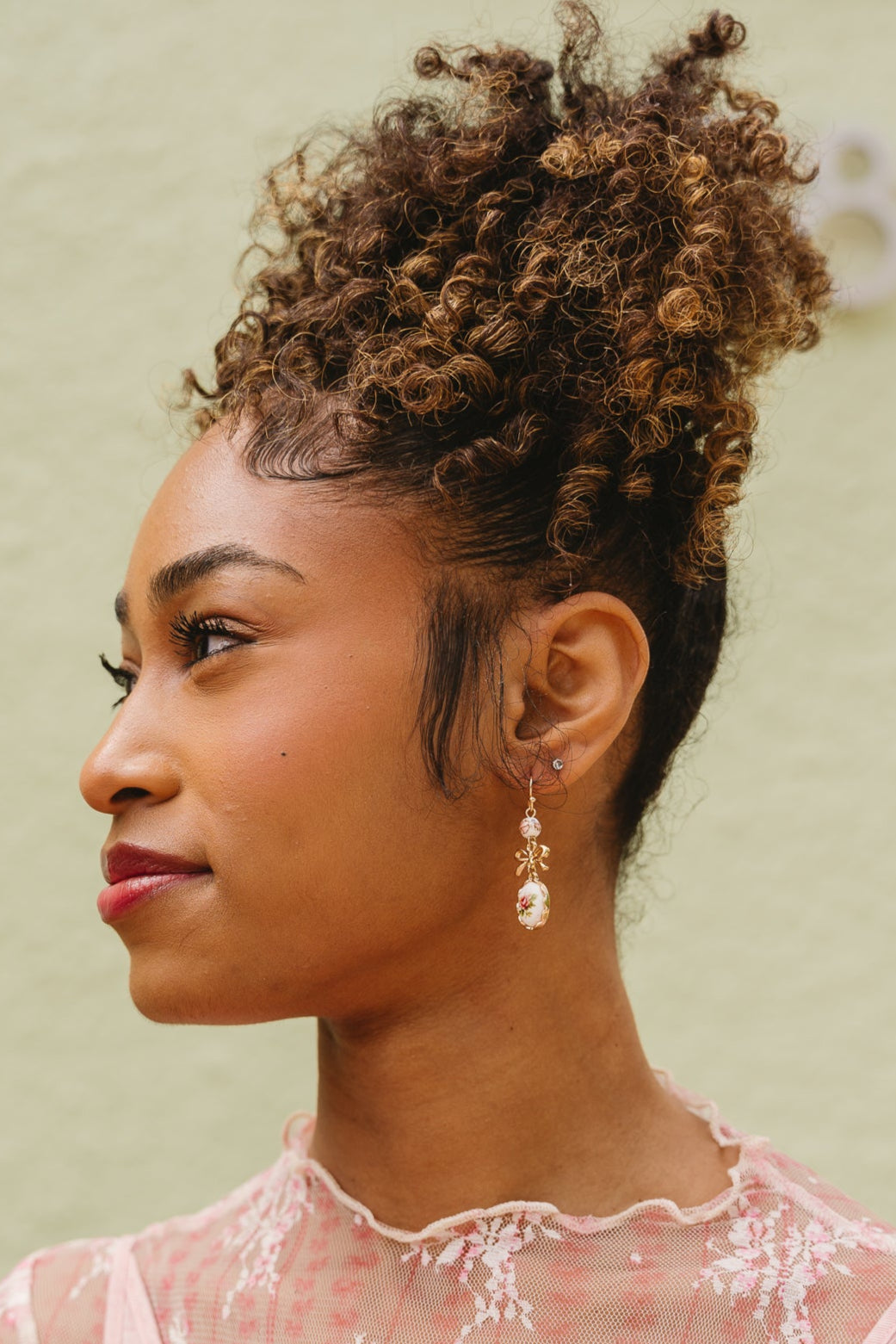 Cady Vintage Floral Bow Earrings - side view of earrings on model