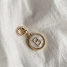 Image shows the 'B' alphabet charm against a white background. Charm is a gold circle with pearlescent center and has gold letter B in the center.