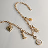 Image shows the bottom of the Kennedy Gold Chain Link Necklace against a white background. Necklace has gold circle and oval links. Shown with 6 assorted charms added.