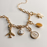 Image shows the Reagan Gold Chain Link Bracelet against a white background. Bracelet has gold circle and oval links. Shown with 5 assorted charms attached.