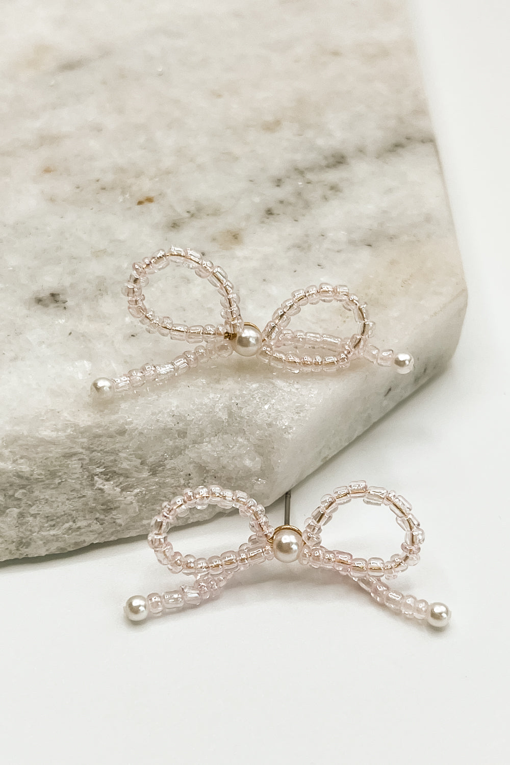 The Paige Bow Earrings are shown against a neutral background.