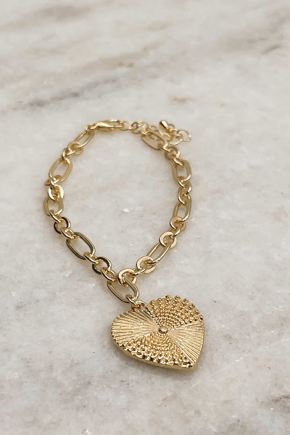  Close up of Juliette Gold Heart Bracelet, gold chain link with gold medallion.