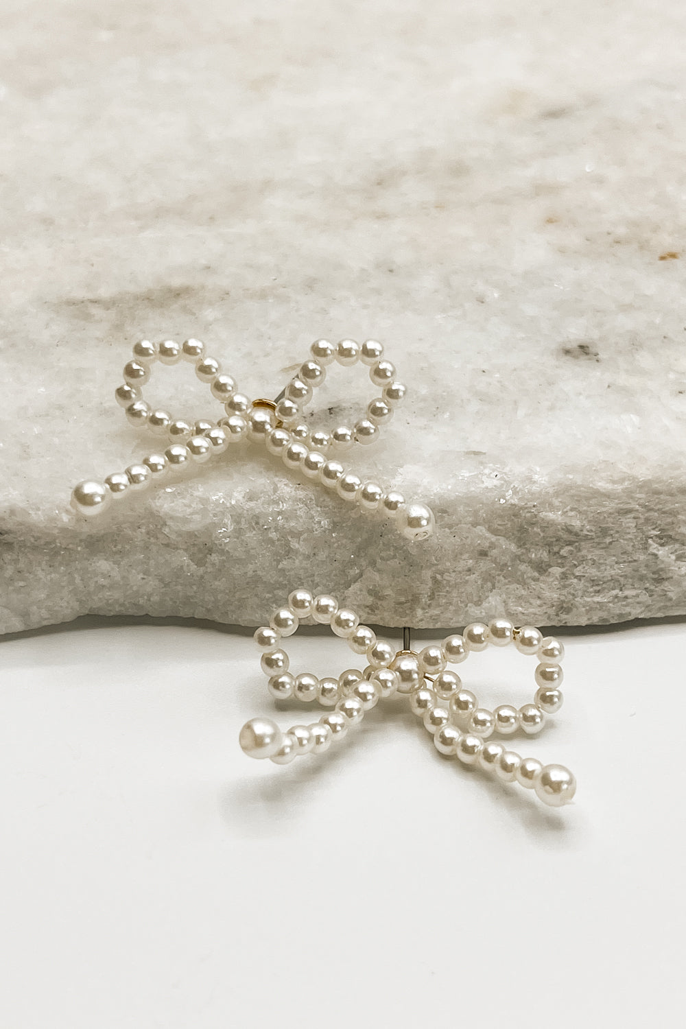 The Capri Bow Earrings are seen in an alternate view against a neutral background.