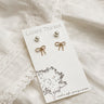 The earring set is seen on a neutral background. The two pairs of earrings are fastened to the card they are packaged in. 