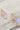 The Daisy Earrings are shown on a neutral background. The wire is gold, while the sequins cascading are iridescent pink.