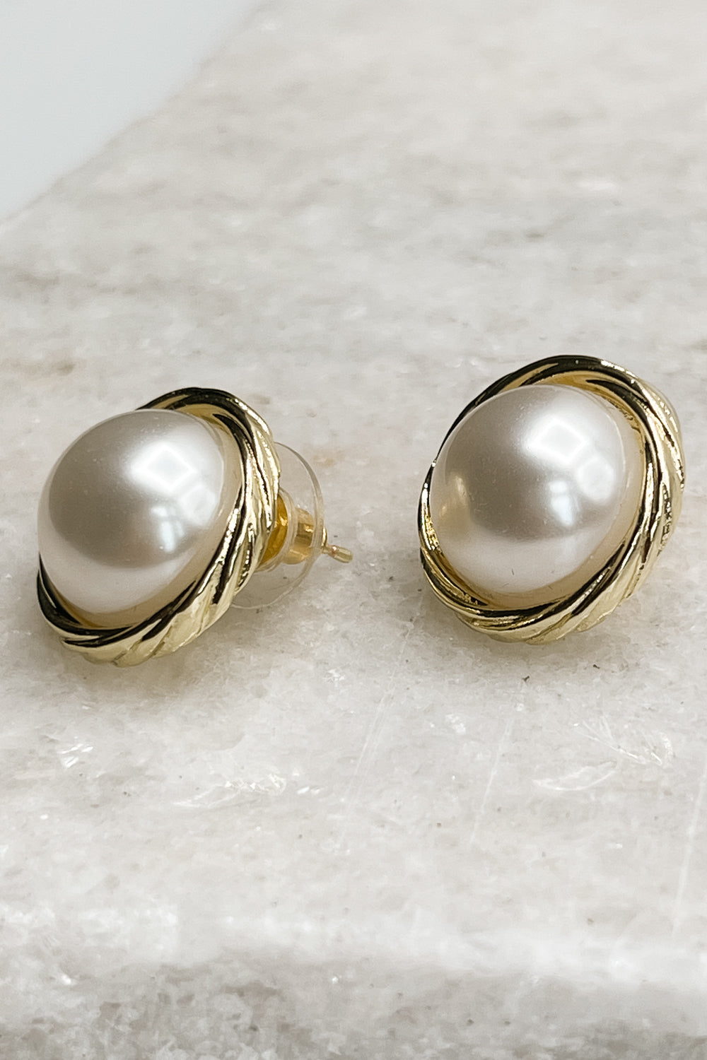 Close up half side view of Camden Pearl Stud Earrings, pearl studs wrapped in gold.