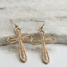 The Catherine Earrings are shown on a neutral background. They are dangle earrings with cross charms. The earrings are gold with pearl accents.