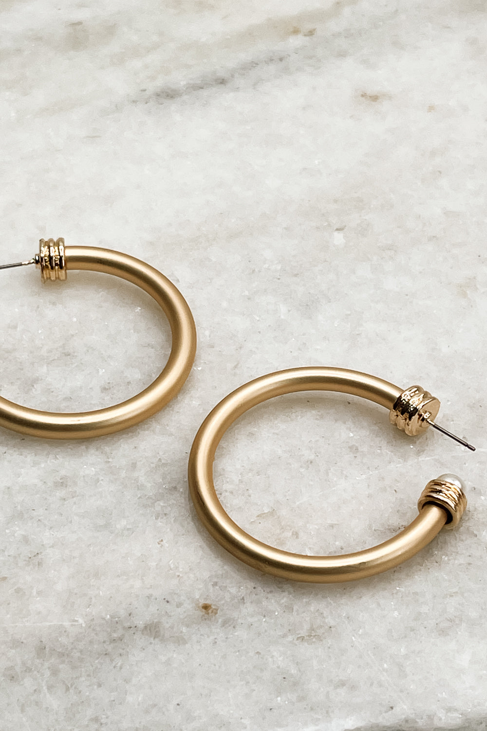 Close up of Hadley Gold Hoop Earrings, brushed gold hoops with pearl end details.