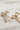 Earrings are shown lying on a neutral background. They are bows with crystal and gold accents. The "ribbons" are made from pink crystals.