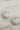 Image shows the Calista Iridescent Scoop Hoop Earrings against a white marble background. Earrings have white iridescent material with open hoop shape.