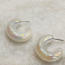 Image shows the Calista Iridescent Scoop Hoop Earrings against a white marble background. Earrings have white iridescent material with open hoop shape.