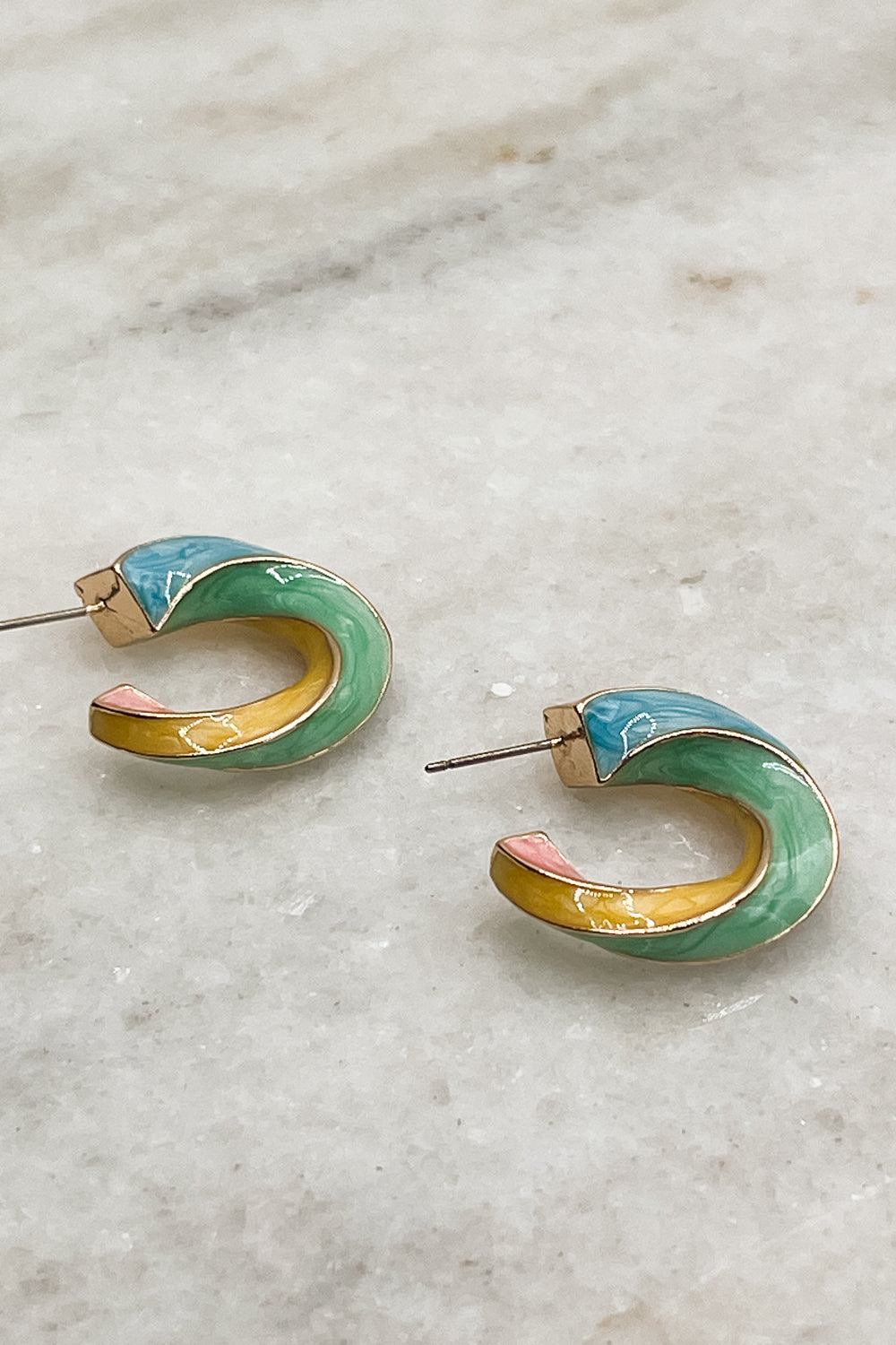 Earrings are shown on a neutral background. They are twisted hoops with blue, pink, yellow-orange, and green accents. Alternate view.