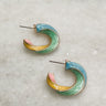 Earrings are shown on a neutral background. They are twisted hoops with blue, pink, yellow-orange, and green accents.