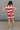 back view of female model wearing the Bristol Red & White Stripe Sleeveless Top which features Red and Cream Stripe Lightweight Fabric Slits on the side, Round Neckline and Sleeveless