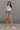 full body view of female model wearing the Love America Cream Knit Tank which features Cream Knit Fabric, Round Neckline, Sleeveless and Red Stitch Heart, Says America in blue stitch writing
