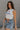 side view of female model wearing the Love America Cream Knit Tank which features Cream Knit Fabric, Round Neckline, Sleeveless and Red Stitch Heart, Says America in blue stitch writing