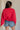 back view of female model wearing the USA 1996 Red Long Sleeve Sweatshirt which features Lightweight Red Fabric, Round Neckline, Long Sleeves, Ribbed Hem and USA 1996 graphic with white, red and blue stitch design