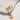 flat lay view of the Snake Ribbed Gold Circle Huggie Earrings which features gold huggies with snake ribbed circle medallions