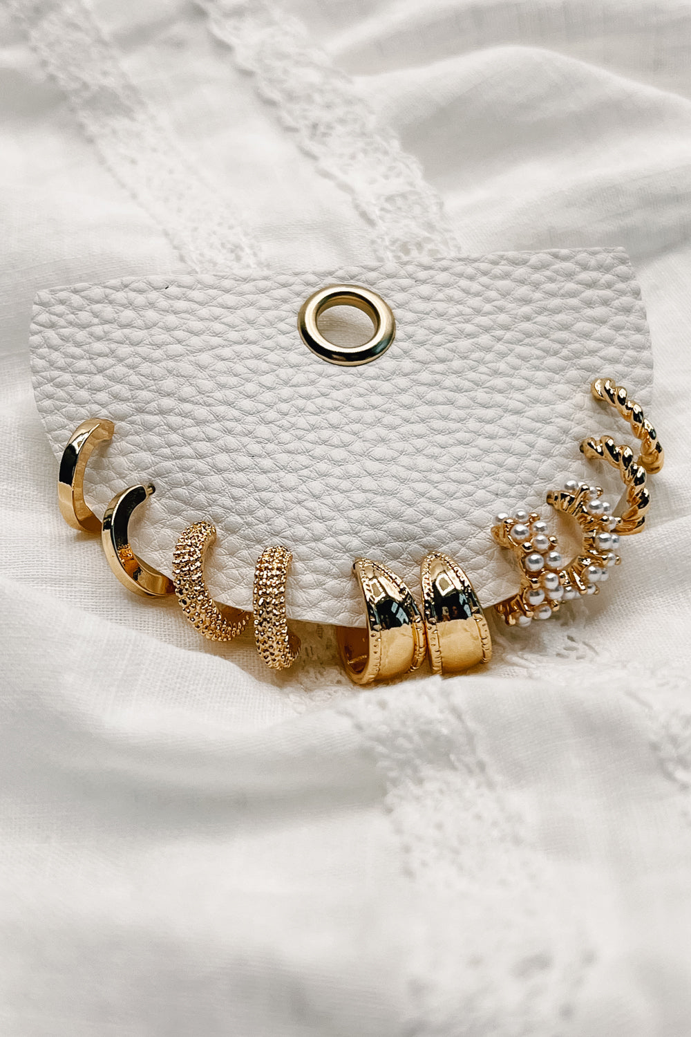 A close-up view of the Annie Earring Set in gold.  The set features 5 pairs of earrings varying in style. More details in the product description.
