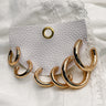 A close up of the Rochelle  gold earring set. Featured are three sets of gold hoops varying in size.