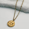 Image shows Samara Gold Snake Medallion Necklace against a white background. Necklace has a gold chain and a circle gold pendant that has a snake on it.