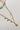 The Mariposa Necklace is shown in a close-up. The necklace features two chains; one herringbone, and one with butterfly charms.