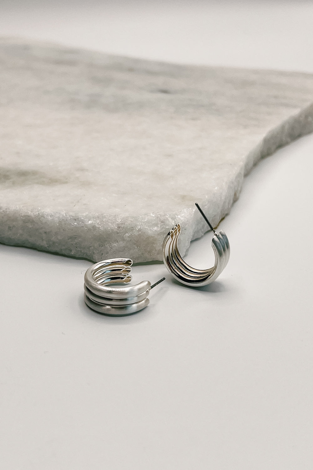 Close up of Elise Silver Ribbed Mini Hoops.