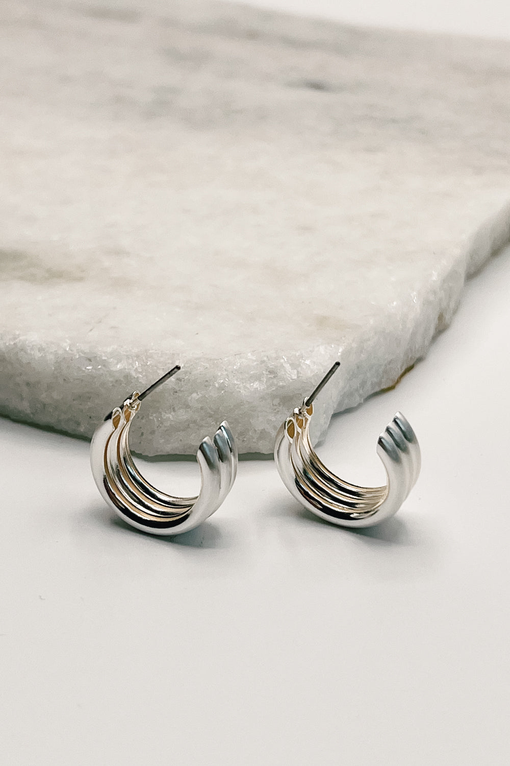 Close up of Elise Silver Ribbed Mini Hoops.
