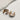 The photo shows the Meg earrings lying on a neutral background.