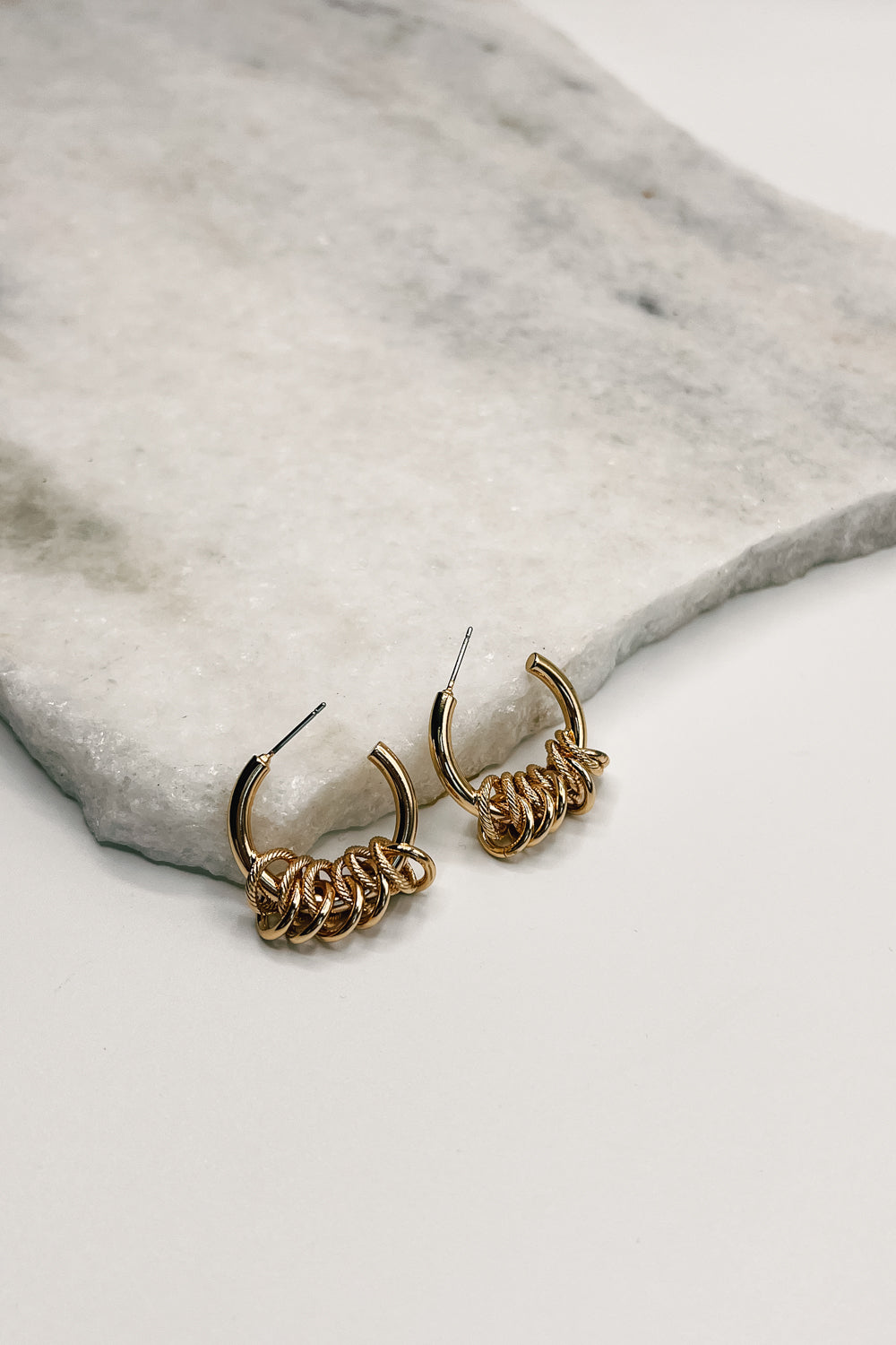 an alternate view of the Evangeline Hoops are shown on a neutral background. The hoops feature an open design and are adorned with smaller ribbed hoops.