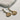 Close up of the Maris Shell earrings.  The Maris earrings feature pearls and a gold seashell charm.