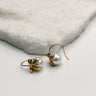 flat lay view of the Lara Pearl & Gold Bow Earring which features small gold dangle earrings with pearl and bow detail