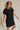 side view of female model wearing the Elsie Ribbed Short Sleeve Mini Dress which features Ribbed Fabric, Mini Length, Left Front Chest Pocket, Short Sleeves and Round Neckline. the dress is available in black and blue.