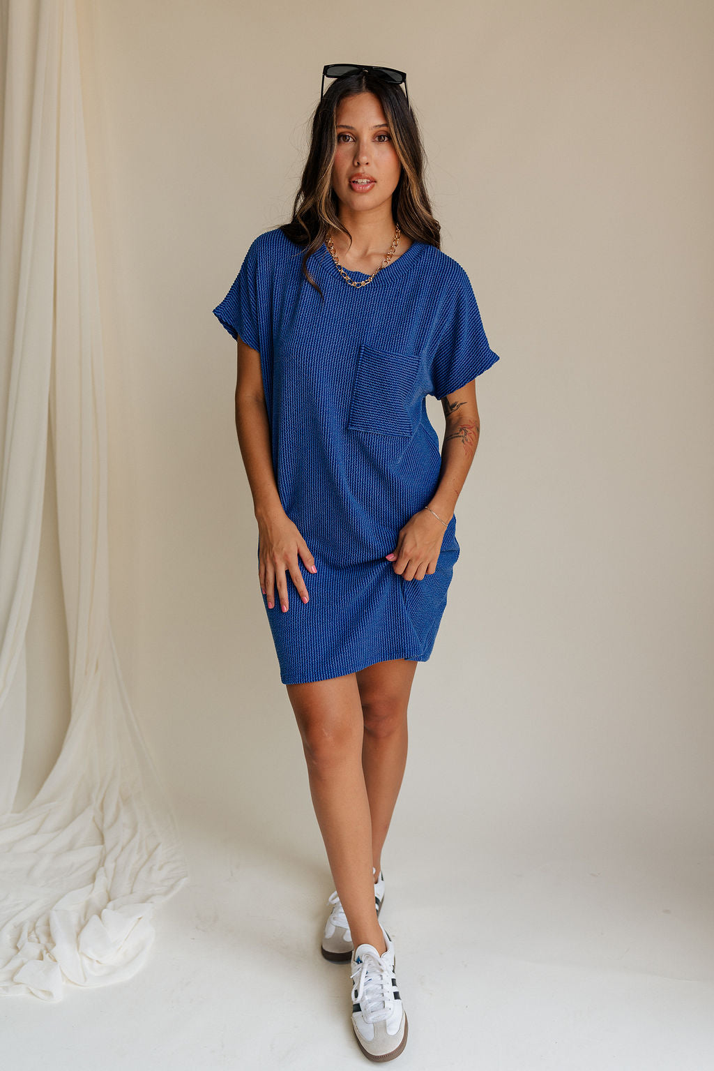 full body view of female model wearing the Elsie Ribbed Short Sleeve Mini Dress which features Ribbed Fabric, Mini Length, Left Front Chest Pocket, Short Sleeves and Round Neckline. the dress is available in black and blue.