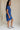 full body side view of female model wearing the Elsie Ribbed Short Sleeve Mini Dress which features Ribbed Fabric, Mini Length, Left Front Chest Pocket, Short Sleeves and Round Neckline. the dress is available in black and blue.