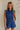 front view of female model wearing the Lila Navy Denim Button-Up Romper which features Navy Blue Washed Fabric, Two Front Pockets, Two Back Pockets, Front Zipper with Button Up Closure, Collared Neckline and Sleeveless