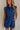 front view of female model wearing the Lila Navy Denim Button-Up Romper which features Navy Blue Washed Fabric, Two Front Pockets, Two Back Pockets, Front Zipper with Button Up Closure, Collared Neckline and Sleeveless